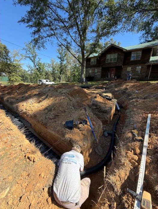 Precision Services technician installing a new septic field line in McCalla, AL